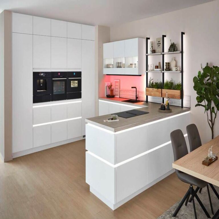 Moderne grifflose Küche in Weiß mit beleuchteter Kochinsel und Kräuterregal – Küchenstudio Leverkusen